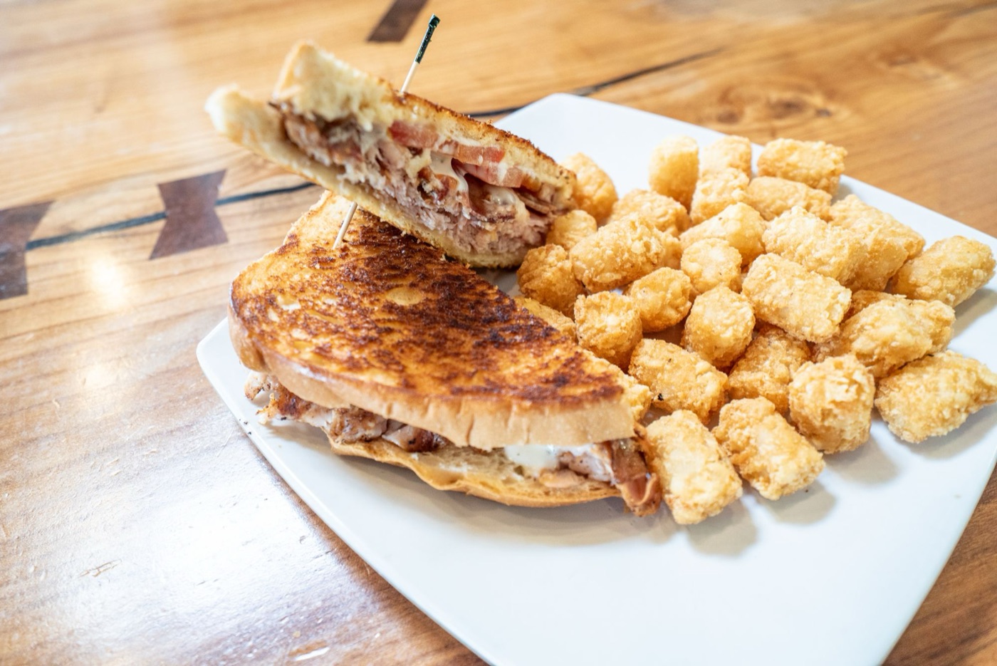 Turkey Bacon Swiss on grilled sourdough with tots